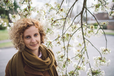 Beautiful woman by blossoms in park during spring