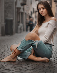 Beautiful young woman sitting on floor