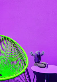 Summer armchair against purple wall. home decor in detail. minimalist aesthetic.