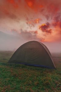 Tent on field against sky during sunrise