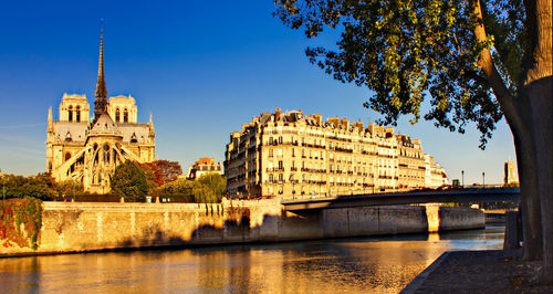 Bridge over river against buildings in city