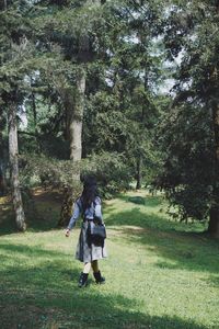 Rear view of woman walking on field