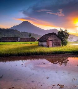 Scenic view of field by mountains against sky