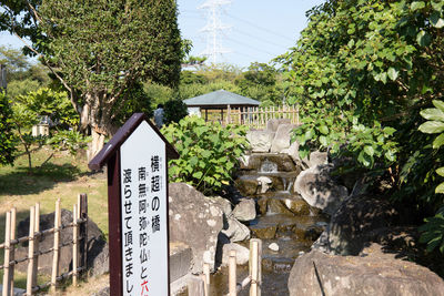 Information sign by tree against building