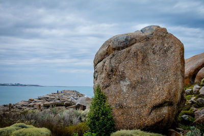 Rock formations by sea against sky