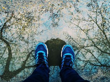 Low section of man standing in puddle