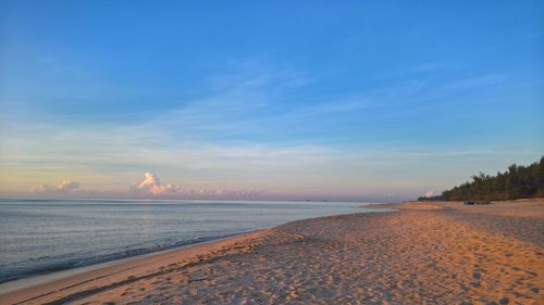 Scenic view of beach against blue sky