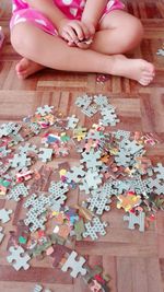 Low section of child playing with jigsaw puzzle