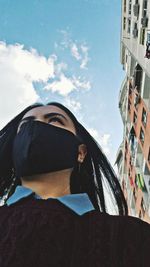 Low angle view of man and woman against sky in city