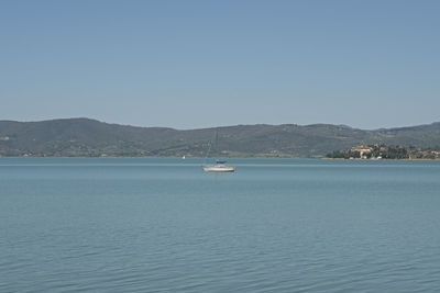 Sailboat sailing on sea against clear sky