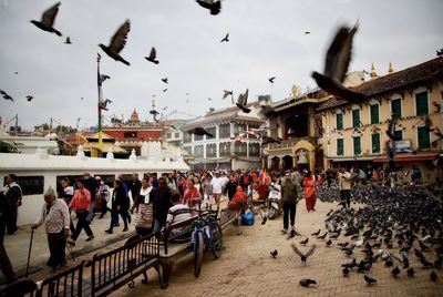 Group of people at town square against sky