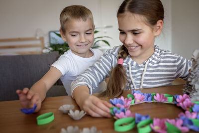 Kids create easter flower wreath in pastel colors using an upcycled egg trail. zero waste lifestyle