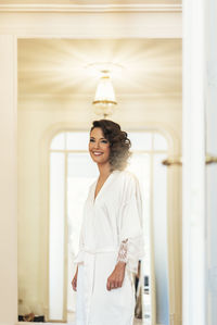 Young woman standing against building