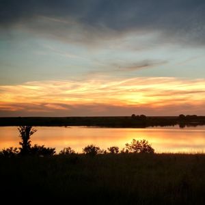 Scenic view of lake against sky during sunset