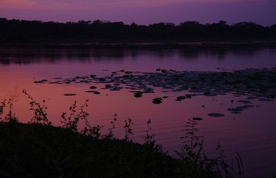 Scenic view of lake against sky at sunset