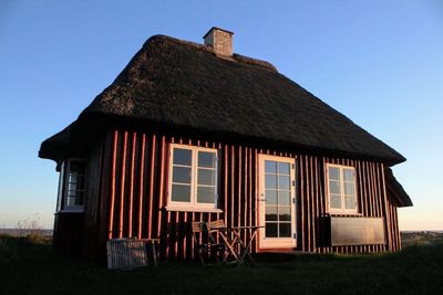 Exterior of house on field against clear sky