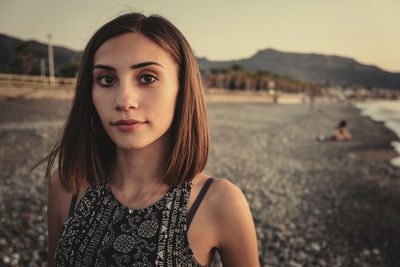 Portrait of beautiful young woman standing on land