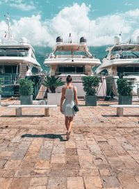 Rear view of woman on swimming pool against sky