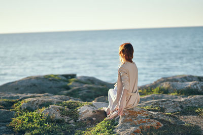 Rear view of woman looking at sea against sky