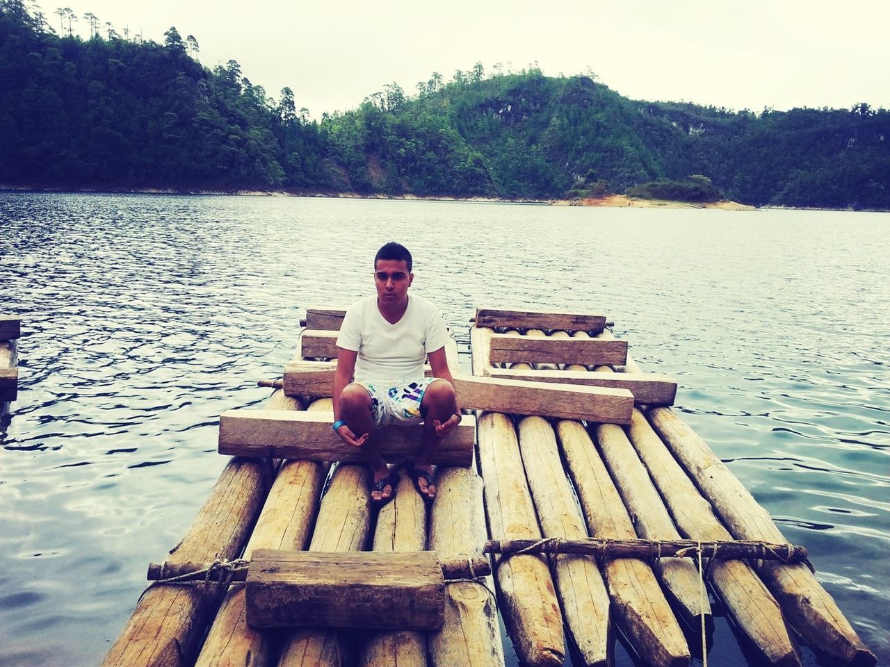 water, lake, lifestyles, leisure activity, tree, river, sitting, day, nature, tranquility, men, outdoors, standing, tranquil scene, reflection, wood - material, young adult, holding