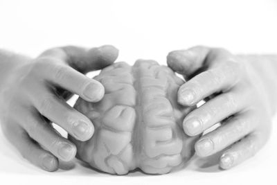 Close-up of woman with hands over white background