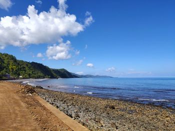 Scenic view of beach against blue sky