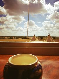 Close-up of tea cup against sky