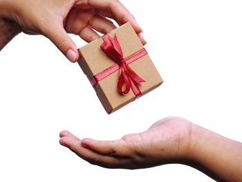 Low angle view of person hand holding box against white background