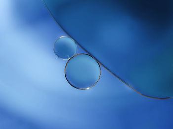 Low angle view of bubbles against blue sky