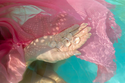 High angle view of woman holding crystal in swimming pool