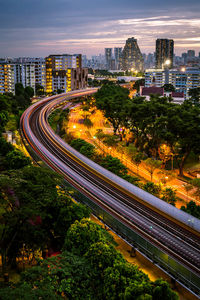 High angle view of light trails on road amidst buildings in city
