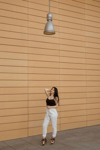 Portrait of woman standing against wall