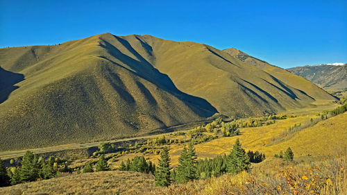 Scenic view of mountains against clear blue sky