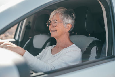 Senior woman sitting in car
