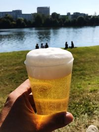Man drinking water in front of lake