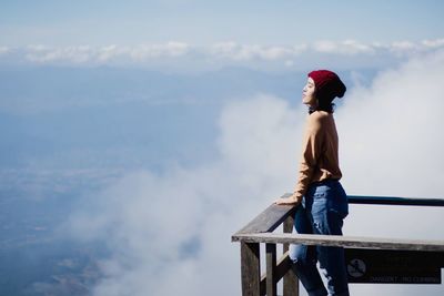 Side view of woman standing against sky