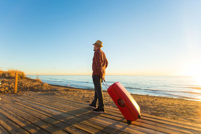 Man on beach against clear sky