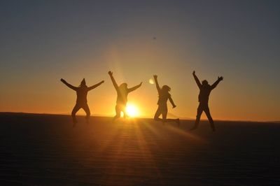 Silhouette people at beach during sunset