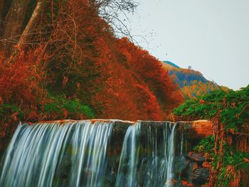 Close-up of waterfall against sky during autumn