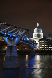 Illuminated millennium bridge over river thames  against sky at night with st. paul's cathedral dome