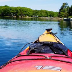 Rear view of man sitting on boat against lake