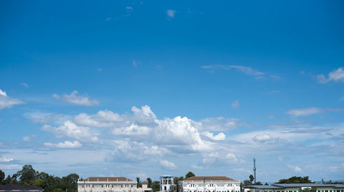 Buildings in city against blue sky