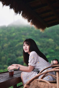 Portrait of a young woman sitting outdoors