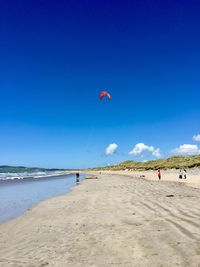 Scenic view of beach against blue sky