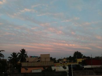 Buildings against cloudy sky at sunset