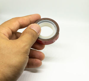 Close-up of person holding hand over white background