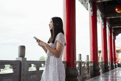 Side view of woman using mobile phone