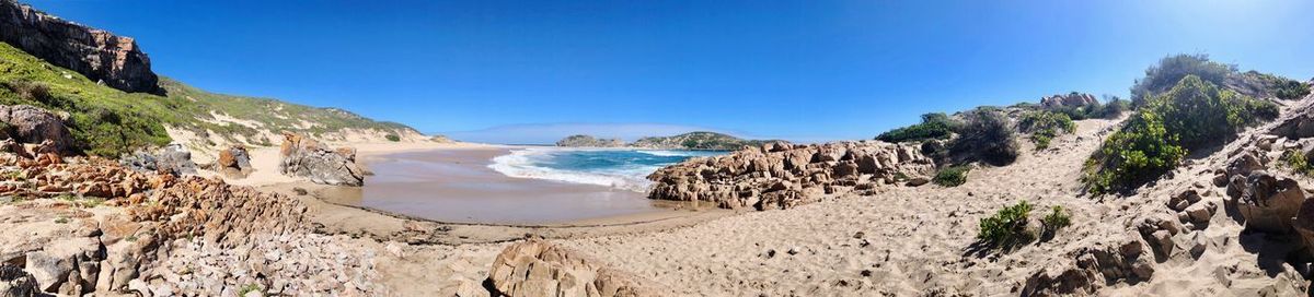 Panoramic view of beach against clear blue sky