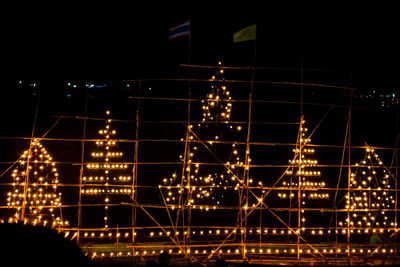 Low angle view of illuminated lights against sky at night