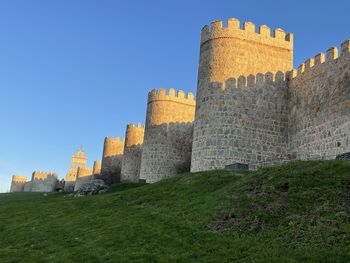 Low angle view of avila city wall  against clear sky
